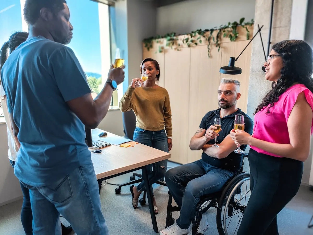 Varias personas trabajando alrededor de una mesa en una oficina luminosa.